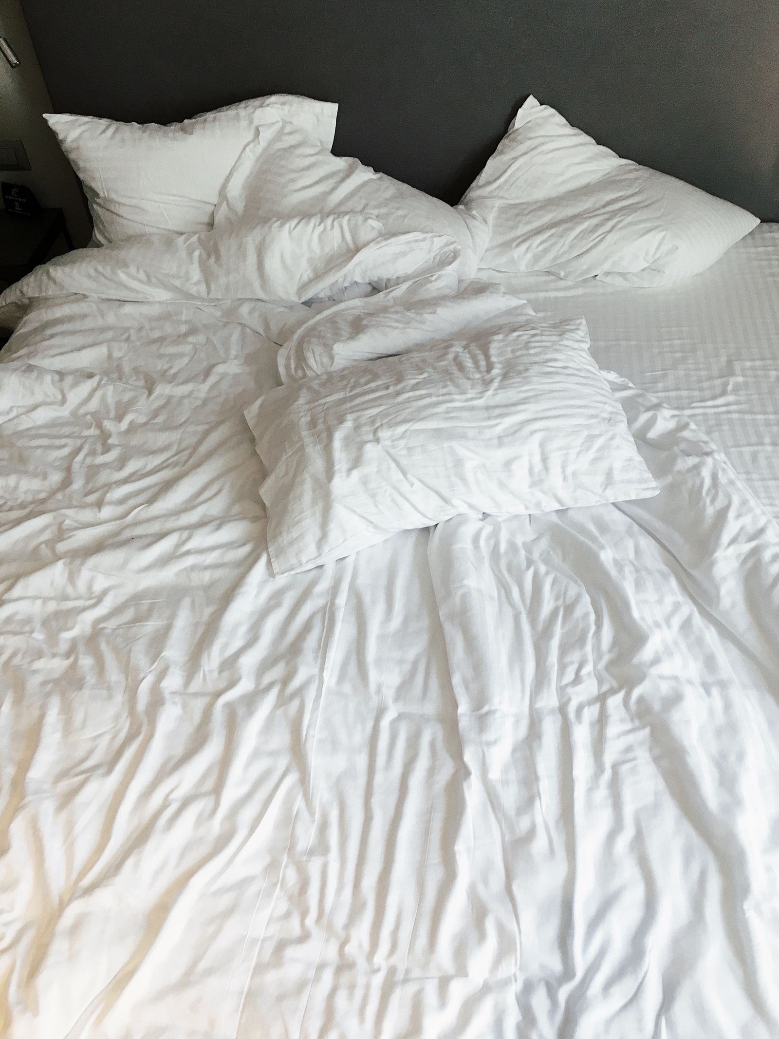 Neatly made white hotel bed with folded linen